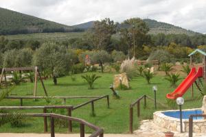 a playground with a red slide and a pool at Agriturismo Isidoro in Fertilia