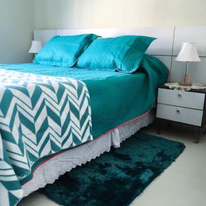 1 dormitorio con 1 cama con almohadas azules y mesita de noche en Depto Metro Santa Ana (2 dormitorios), en Santiago
