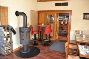 a room with a wood stove and red chairs at Gasthof Keilbach in Sindelfingen