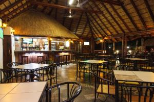 a restaurant with tables and chairs and a bar at Swadini, A Forever Resort in Hoedspruit