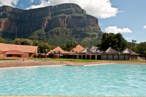 a large swimming pool with a mountain in the background at Swadini, A Forever Resort in Hoedspruit