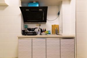 a kitchen with a counter top with a microwave at XiNing Chengxi ·Wanda square· in Xining