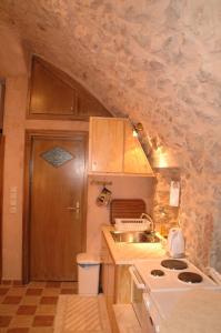 a small kitchen with a sink and a stove at Stoneapartments, Γ ΚΩΣΤΑΛΟΣ ΚΑΙ ΣΙΑ ΟΕ in Avgonyma