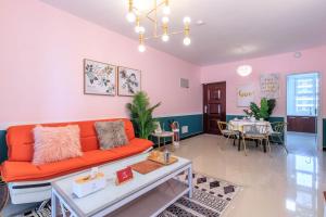 a living room with an orange couch and a table at Baoding Lianchi·Baoding East Station· Locals Apartment 00163450 in Baoding