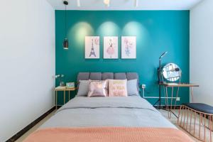 a bedroom with a bed with a blue wall at Baoding Lianchi·Baoding East Station· Locals Apartment 00163450 in Baoding