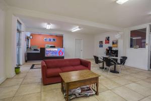 a living room with a red couch and a table at Motel 6-Brinkley, AR in Brinkley