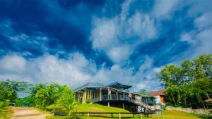 a house on a hill with a blue sky at Binlha Raft Resort in Sai Yok