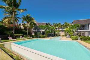 a swimming pool in a villa with palm trees at Plage Bleue Beachfront Apartments by LOV in Trou aux Biches
