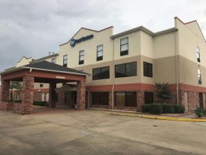 un edificio con un estacionamiento delante de él en Best Western Rayne Inn, en Rayne