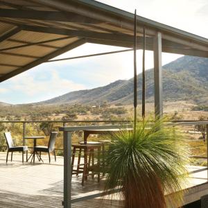 a deck with tables and chairs and a view of mountains at Pichi Richi Park in Quorn
