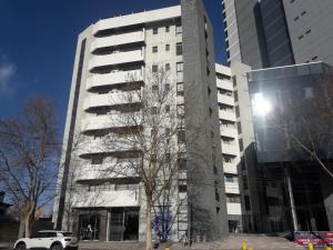 a white car parked in front of a tall building at Departamento Torre Sofitel in Río Cuarto