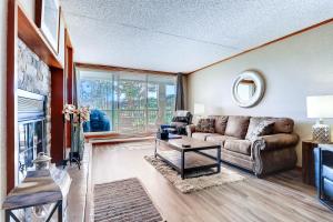 ein Wohnzimmer mit Couch und Kamin in der Unterkunft Spacious And Modern 2Br Premier- The Pines- Kids Ski Free Condo in Keystone