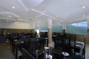 a dining room with tables and chairs and windows at Moonline Resort in Anaviratty