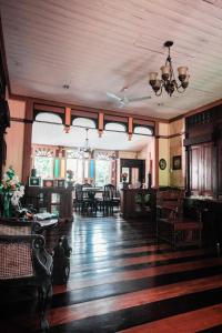a living room with tables and chairs and a ceiling at Oasis Balili Heritage Lodge in Tagbilaran City