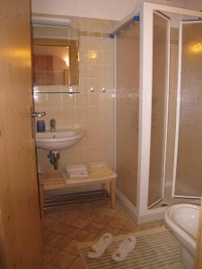- une salle de bains pourvue d'un lavabo et d'une douche avec des chaussures à l'étage dans l'établissement B&B Anna Maria, à Ledro