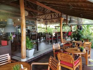 an empty restaurant with wooden tables and chairs at Baan Manali Resort in Thong Sala