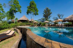 uma piscina num resort com cadeiras e guarda-sóis em 98 Acres Resort & Spa em Ella