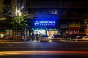 two cars are parked in front of a haloeyes hub at night at Nomad's Hub - Best Value Co-living Hostel in Cebu City