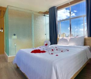 Un dormitorio con una cama blanca con flores rojas. en 99 Bui Vien Hotel (Boutique), en Ho Chi Minh