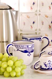 a group of blue and white cups and a bunch of grapes at Masseria Torca - Isca in Massa Lubrense