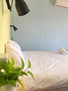 a bedroom with a bed with a lamp and a plant at Say Hi B&B in Manzhou