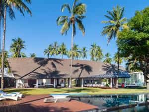 a resort with a swimming pool and palm trees at Villa Sapi by Elite Havens in Tanjung