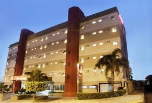 duży budynek z palmami przed nim w obiekcie JR Hotel w mieście Presidente Prudente