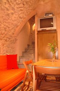 een woonkamer met een tafel, een bank en een televisie bij Stoneapartments, Γ ΚΩΣΤΑΛΟΣ ΚΑΙ ΣΙΑ ΟΕ in Avgonyma
