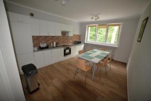 a kitchen with a table and chairs in a room at Pałac w Porażynie in Opalenica