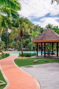 a park with a gazebo and palm trees at Rimbun Suites & Residences in Bandar Seri Begawan