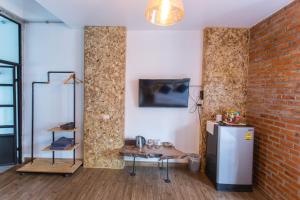 una camera con tavolo e muro di mattoni di Indiego Space a Loei