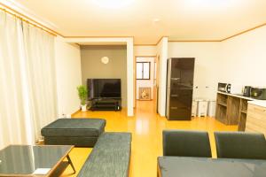 a living room with a couch and a table at Airstar Chiyo House x M&Z HOUSE in Fukuoka