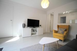 a living room with a tv and a chair at Villa Hyper Centre in Arcachon