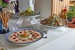 
a table topped with plates of food on top of a table at Ramada Resort Dead Sea in Sowayma
