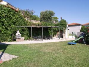 een achtertuin met een tafel en stoelen en een speeltuin bij Apartments Lavanda Fiesa in Piran
