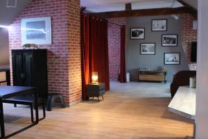 - un salon avec un mur en briques et une table dans l'établissement Une maison en ville, Hyper Centre ville, Spa, à Amiens