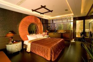 een slaapkamer met een groot bed en een grote spiegel bij Chateau Motel & Spa in Kaohsiung