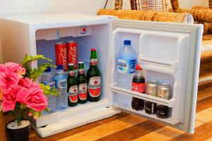 an open refrigerator filled with drinks and soda at Coastal Inn Penida in Nusa Penida