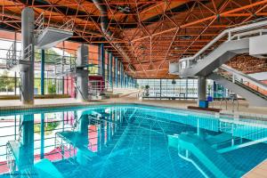 a large swimming pool in a building at Taste Hotel Heidenheim in Heidenheim