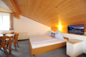 een slaapkamer met een bed en een tafel in een kamer bij Gästehaus Standardhaus in Saalbach Hinterglemm
