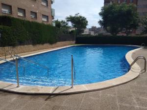 a large blue swimming pool with stairs in a building at R&G SALOU CENTER in Salou +19 photos