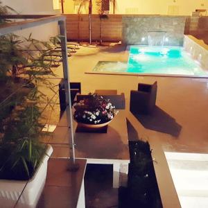 Vianova Affittacamere في جوردينيانو: حمام سباحة مع وعاء من الزهور على الفناء