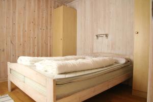 een bed in een kamer met een houten muur bij Myrkdalen Resort Øvre Bygardslii apartment in Vossestrand