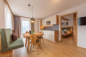 a kitchen and dining room with a table and chairs at Agriturismo MARER Urlaub auf dem Bauernhof in Villabassa