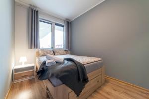 a bedroom with a bed with a large window at Apartament Jaskółcza 30 in Bydgoszcz