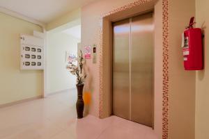 a lobby with a elevator and a vase of flowers at Salin Home Hotel Ramkhamhaeng in Bangkok