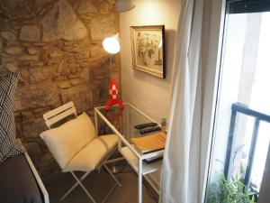 Cette chambre dispose d'une table, d'une chaise et d'un mur en pierre. dans l'établissement Bravissimo Old Side Girona Two, centre Barri Vell, à Gérone