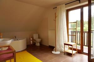 a bathroom with a tub and a toilet and a sink at Leśne zacisze in Rydzewo +11 photos