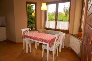a kitchen with a table and chairs and windows at Leśne zacisze in Rydzewo
