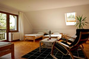 a living room with a bed and a table and chairs at Leśne zacisze in Rydzewo